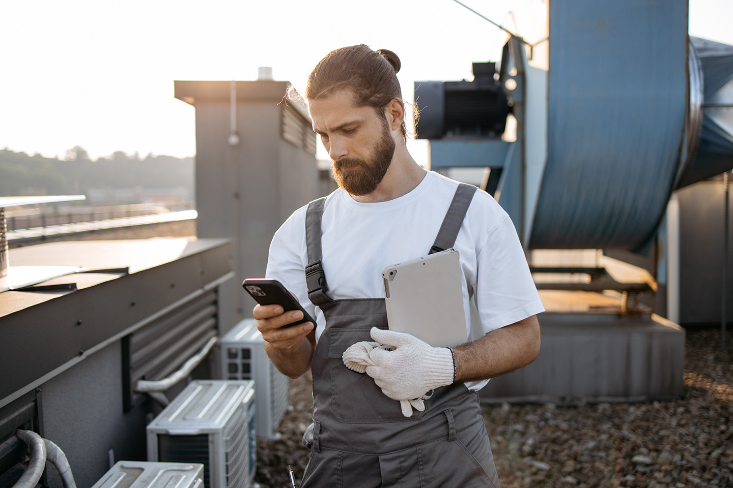 An HVAC technician uses a dispatch software mobile app for service companies