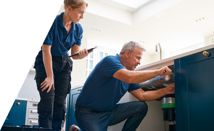Two plumbers using home services management software on a tablet